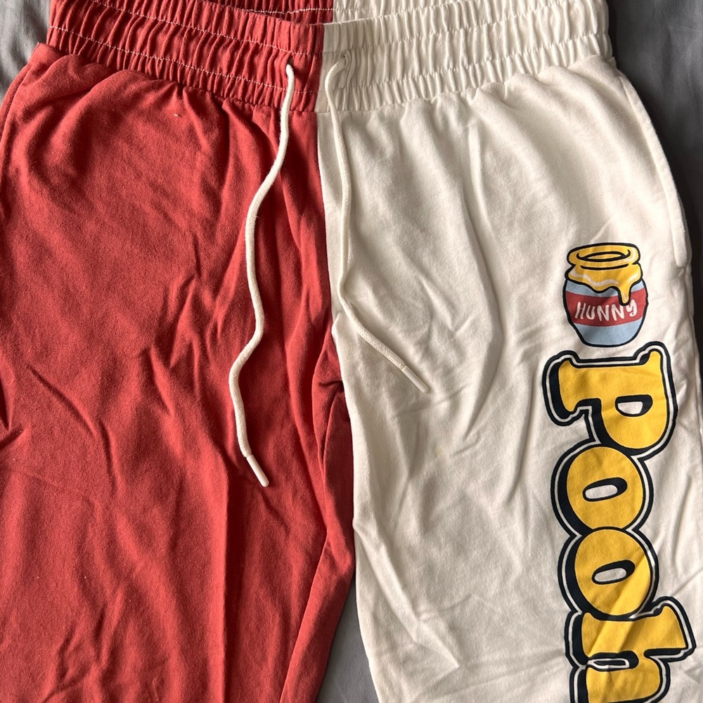 Disney, Winnie the Pooh pants; one side is red and the other is cream.